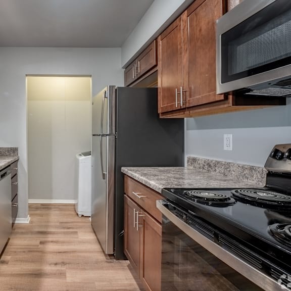 A kitchen with wooden cabinets and a black stove top oven.