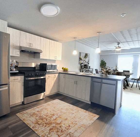 A modern kitchen with a refrigerator, oven, and sink.