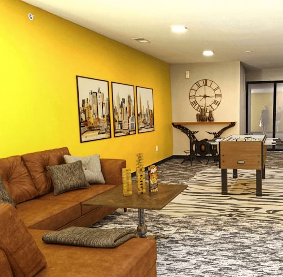 A living room with a yellow wall and a patterned carpet.