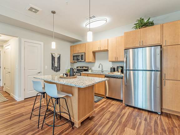 A kitchen with wooden floors and a granite countertop.