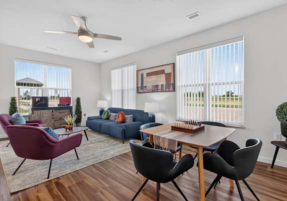 A living room with a red chair, a blue couch, and a wooden dining table.