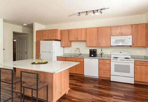 a kitchen with white appliances and wooden cabinets at 67 Flats, Arizona
