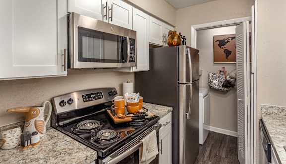 A kitchen with a black refrigerator and stove.