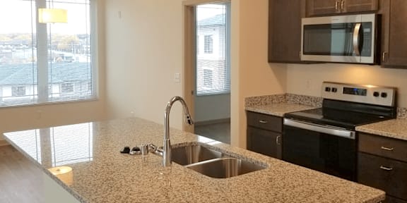 A kitchen with granite countertops and stainless steel appliances.