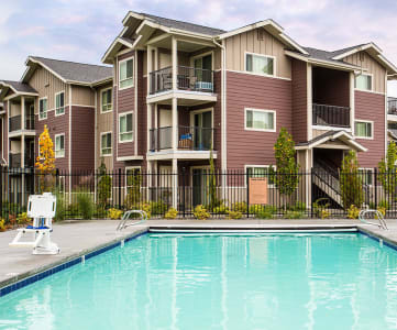 Pool with lounge chairs and apt buildings Vancouver, WA 98684 | Copper Lane Apartments