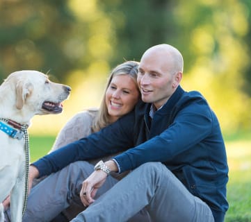 a couple with their dog in a park