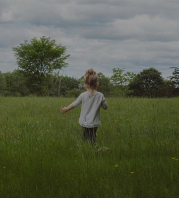 Child playing in a grassy field