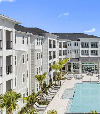 an apartment building with a pool in the middle at Madison Waterford Lakes, Orlando, FL, 32826