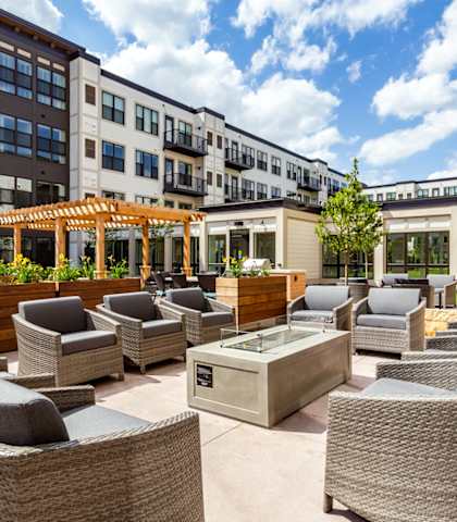 an outdoor patio with chairs and a firepit at the bradley braddock road Enjoy Your Day At Rooftop Deck at The Legends at Berry 62+ Apartments, St. Paul, MN