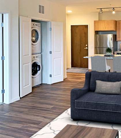 a living room with a couch and a chair in front of a kitchen at Preserve at Shady Oak Apartments, Minnetonka , Minnesota