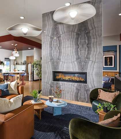 A modern living room with a fireplace and a variety of seating options.