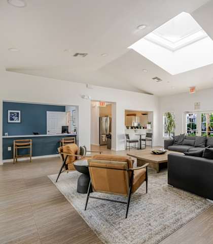 A spacious living room with a skylight and a large sectional sofa.