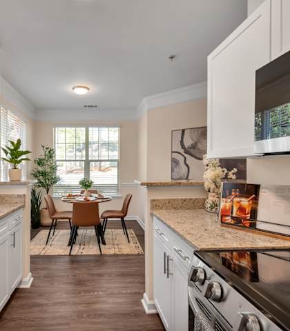A kitchen with a black stove top oven and a sink with a faucet.