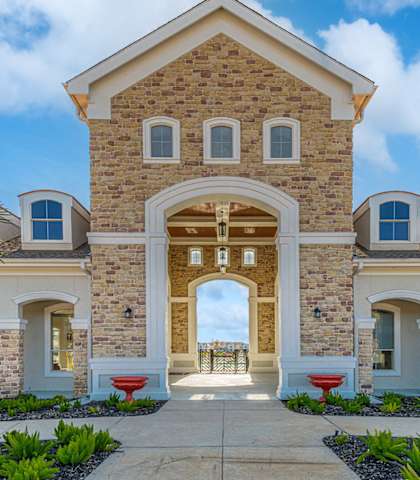 the front of a house with a stone facade and a walkway and a courtyard at Lakeside Pointe Apartments & Townhomes, Pearland, TX, 77584