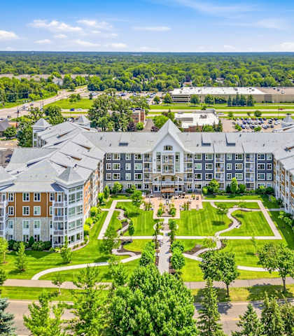 A large, multi-story building with a green lawn in front.
