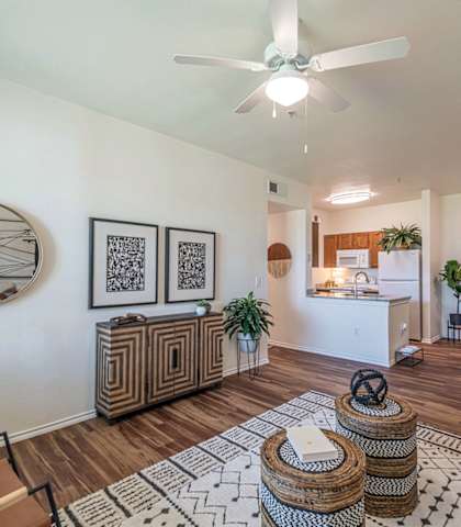 an open living room and kitchen with a ceiling fan and a clock on the wall at Mission at Baytown, Baytown, TX