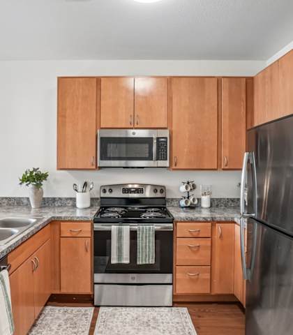A modern kitchen with wooden cabinets and stainless steel appliances.