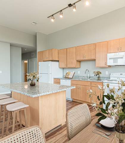 A kitchen with wooden cabinets and a granite countertop at The Paramount Apartments, Atlanta, Georgia