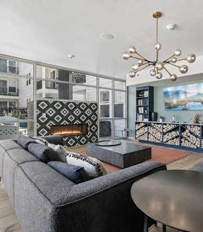 A modern living room with a grey sofa and a black coffee table.