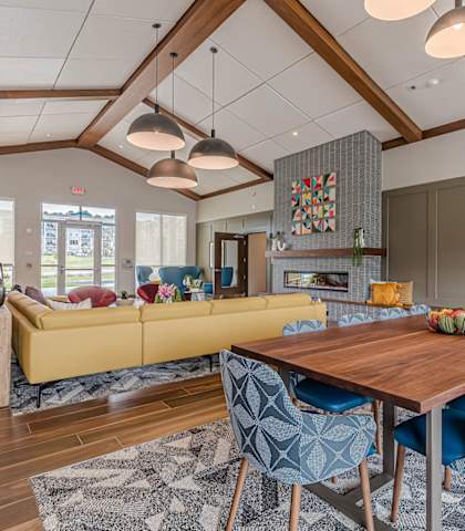 a living room with a dining room table and a yellow couch