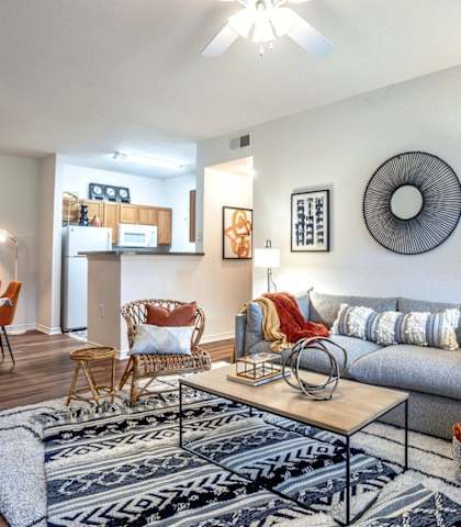 a living room with a couch and a dining room tableat Stoneridge Apartments, Pflugerville Texas