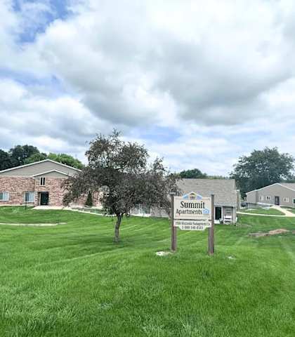 A sign in front of a building that says Summit Senior Living.