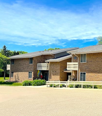 A large brick building with a white fence in front.