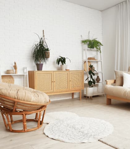 A living room with a white brick wall and a wooden chair.