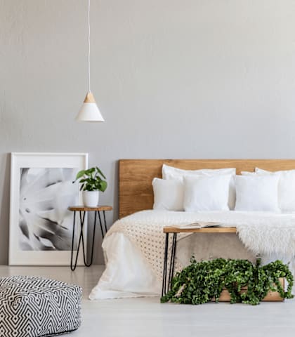 A white bedroom with a large bed and a wooden headboard.