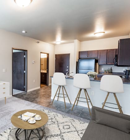 a living room with a tv and a kitchen with a table and chairs