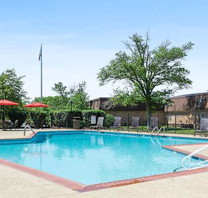 a swimming pool with a building in the background at Madison Rockwood, Ballwin, MO