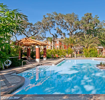 a large swimming pool with trees in the background