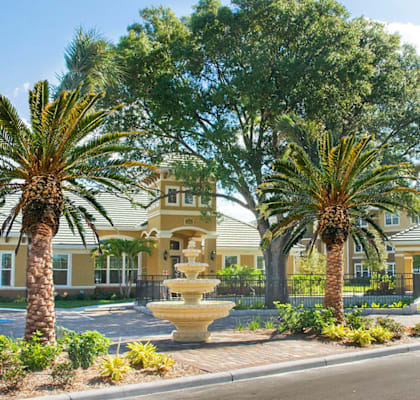 a fountain in the middle of a street in front of a building