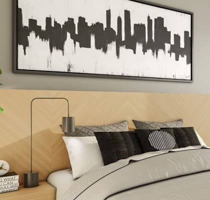 a bedroom with a bed with white and black bedding and a wooden nightstand with a