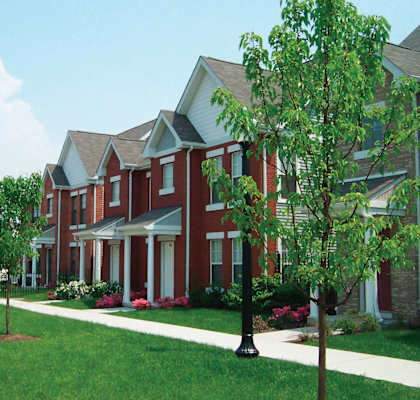 A red brick house with a white door and windows.
