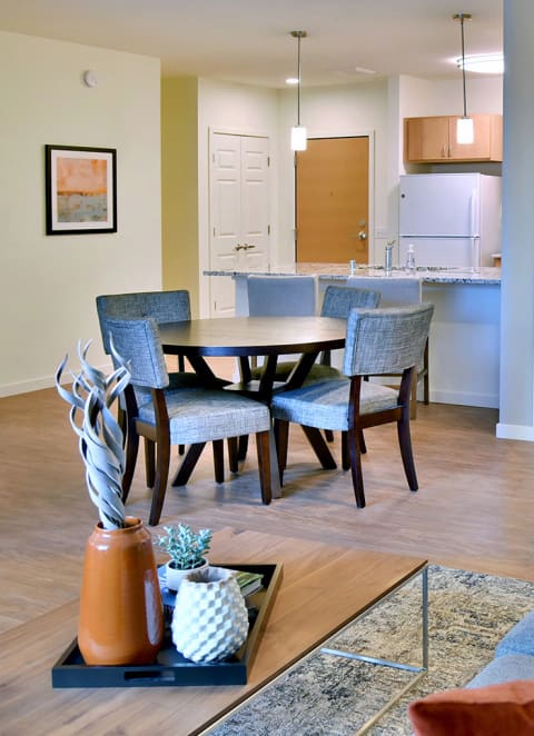 a living room with a couch and a table and a kitchen at The Legends of Woodbury 55+ Apartments, Woodbury, 55129