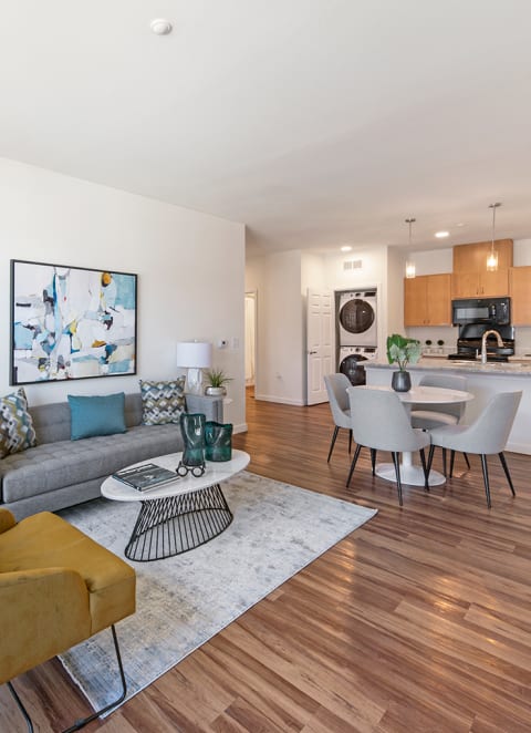 a living room with a couch and a table and a kitchen at Ventura at Tradewinds, Midland, TX, 79706