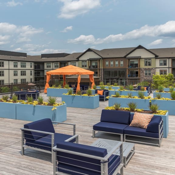 An outdoor deck with blue lounge chairs and an orange gazebo at 2000 West Creek Apartments, Virginia, 23238