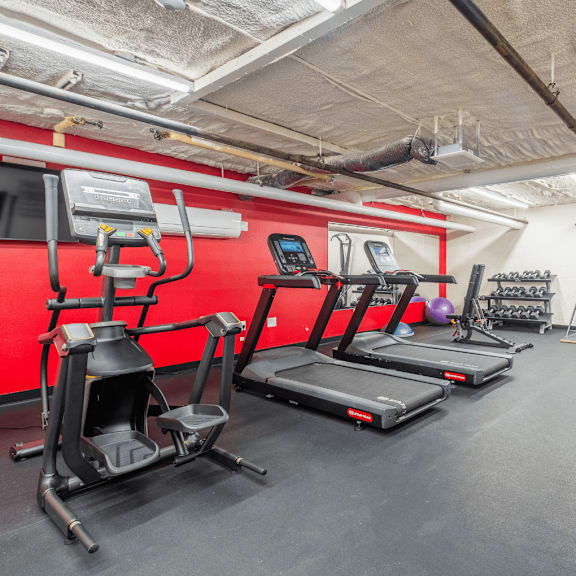 A gym with treadmills, elliptical machines, and other exercise equipment.