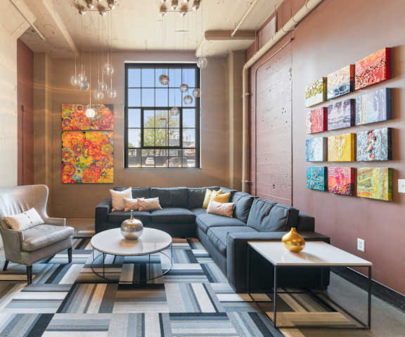 a living room with couches and chairs and a rug at Buzza Lofts of Uptown, MN 55408