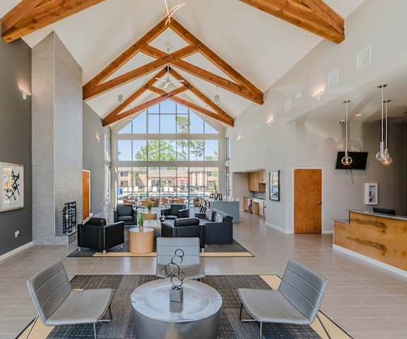 a large lobby with couches and chairs and a large window at Lakecrest Village, Houston
