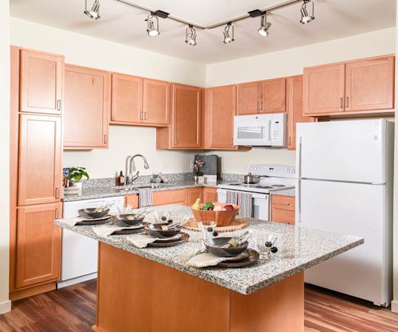 A kitchen with wooden cabinets and a granite countertop.