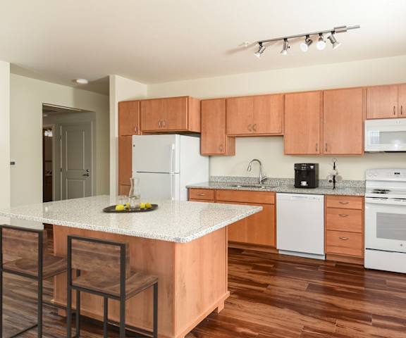 a kitchen with white appliances and wooden cabinets