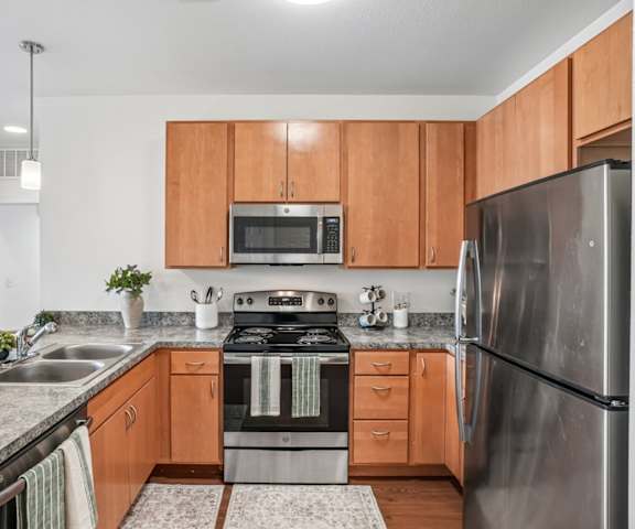 A modern kitchen with wooden cabinets and stainless steel appliances.