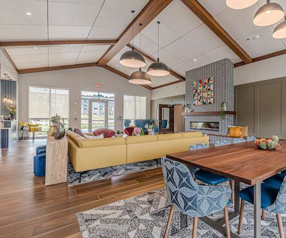 a living room with a dining room table and a yellow couch