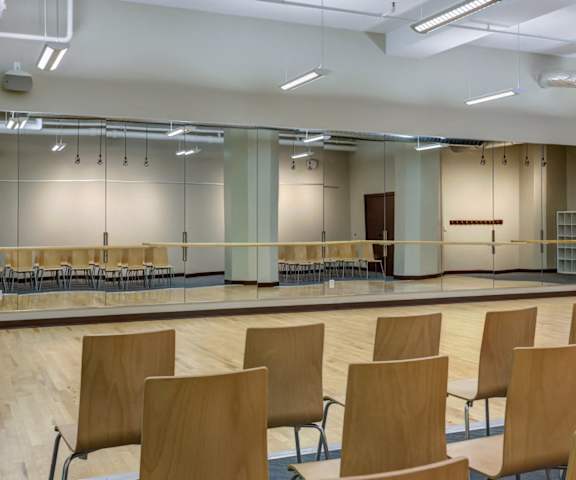 A room with wooden chairs and a stage.