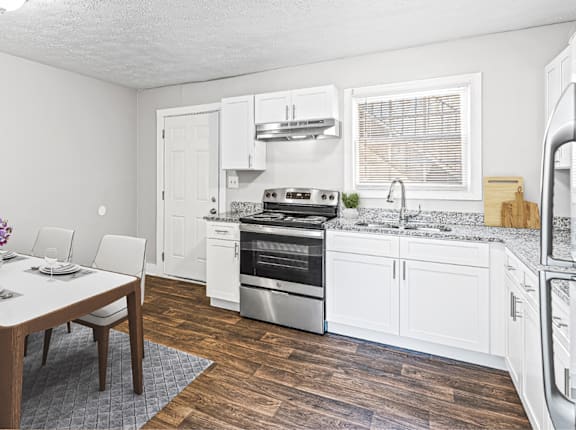 A kitchen with a dining table and chairs at Balfour 296 Apartments in Lilburn, 30047
