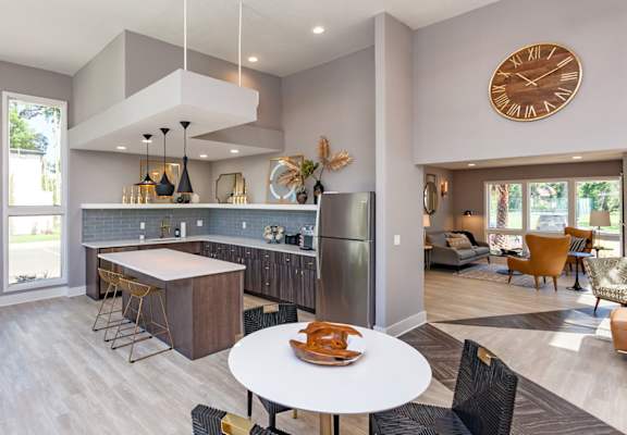 A modern kitchen with a large island and a dining table set for two.