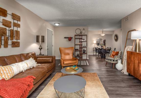 A living room with a brown leather couch and a grey coffee table.