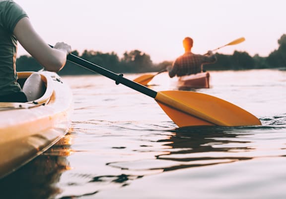two people kayaking at sunset